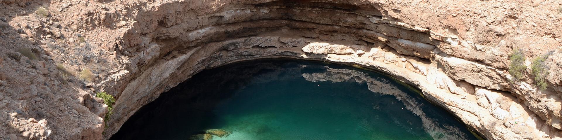 The blue-green water in this limestone formation, Oman 